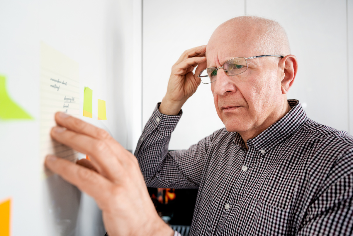 Elderly Man with Dementia Looking at Notes